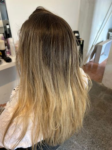 Antes de las mechas: raíz castaña crecida y largos rubio amarillento, en el estudio