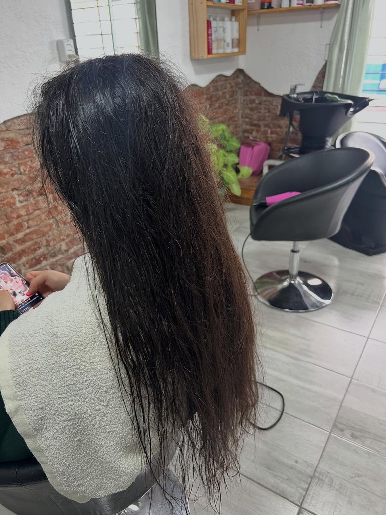 Antes del progresivo: pelo oscuro largo con frizz y ondas sueltas, en el sillón del estudio