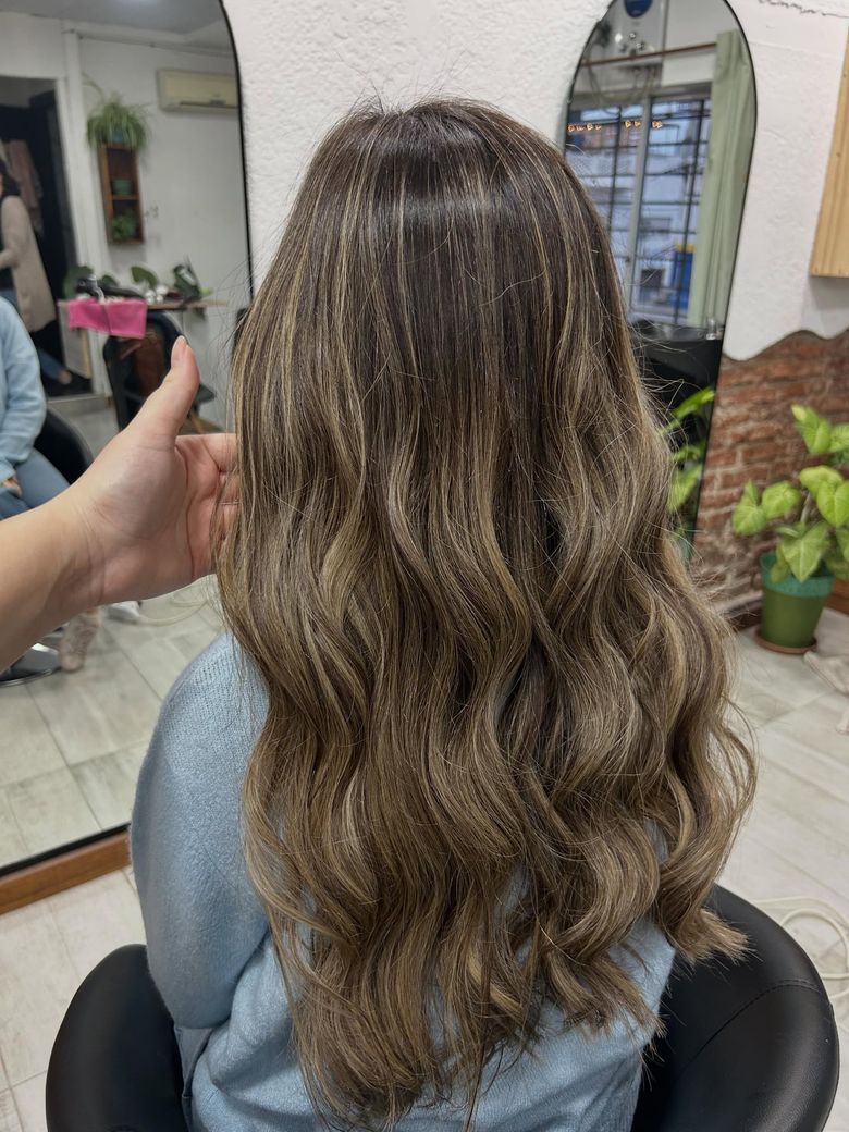 Después del retoque de balayage: ondas largas rubio ceniza, de espaldas en el estudio