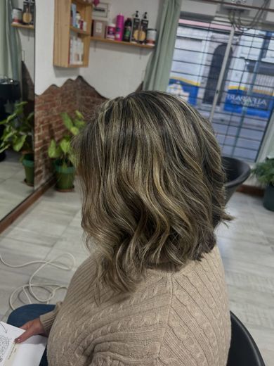 Claritos en pelo corto con ondas: castaño con mechas rubias, de espaldas en el estudio